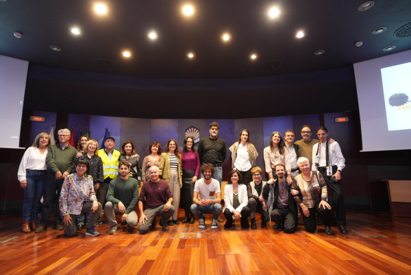 Foto de familia de organizadores, personas premiadas y periodistas participantes en la mesa previa a la entrega de premios.