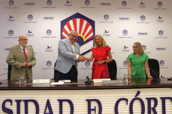El rector y la presidenta de la AECC estrechan manos tras la firma del convenio.