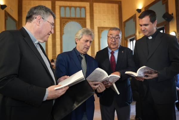 El vicerrector Arenas junto a Navarro y los otros acompañantes de la mesa, hojeando el libro.